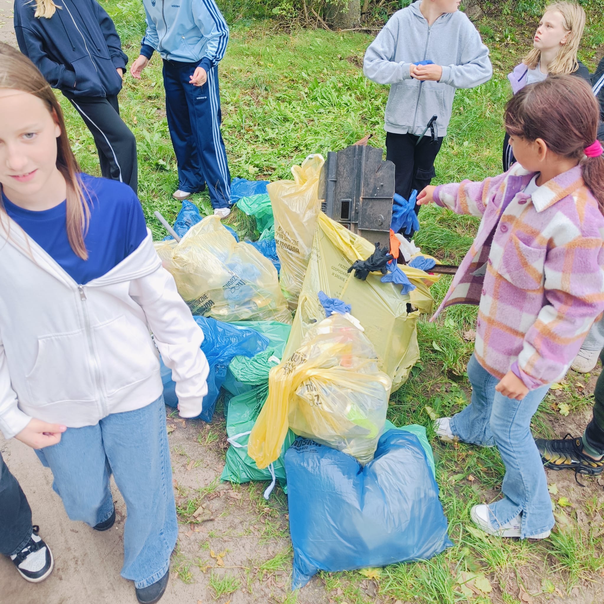 Grupa uczniów z workami pełnymi śmieci
